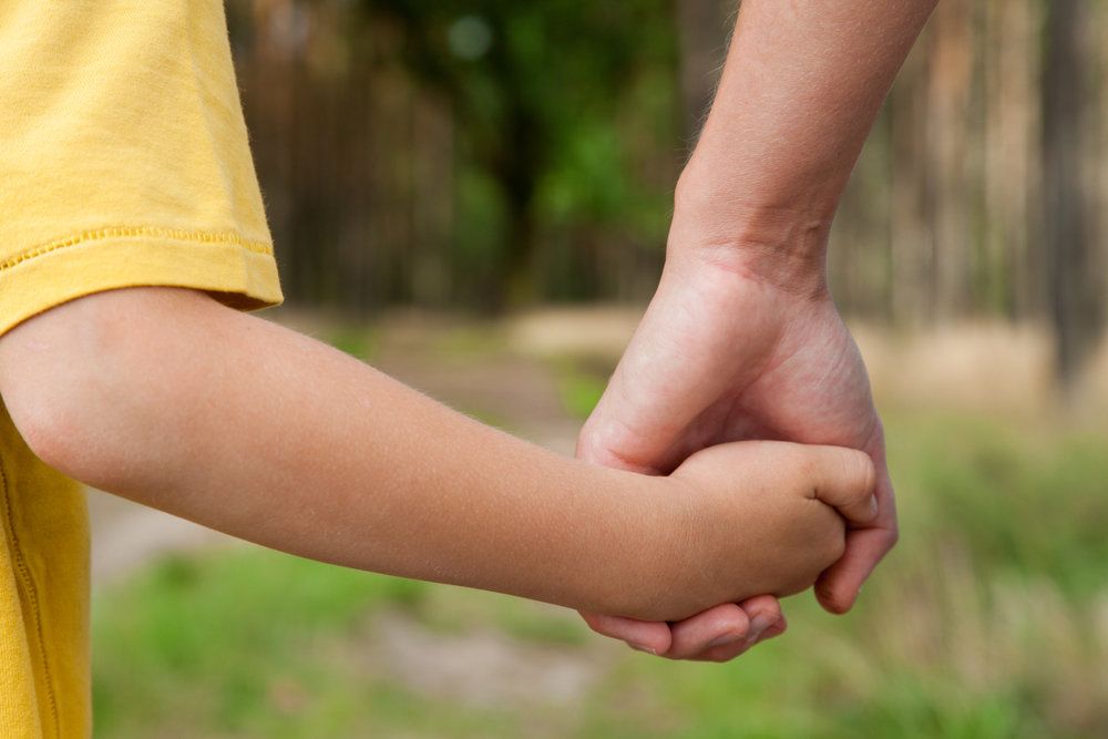 child and parent holding hands
